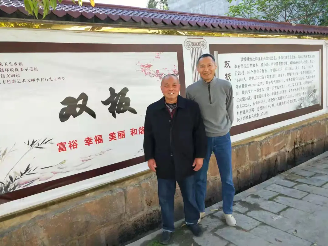 与表哥朱里在乡政府的宣传栏前合影